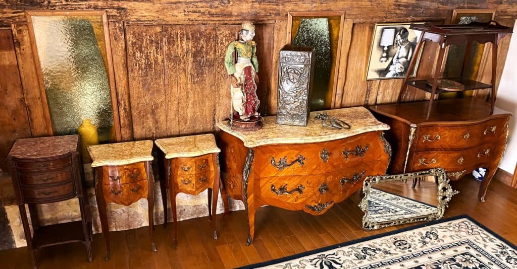 A wooden antique dresser with vintage material around it to represent the difference between antique and vintage.