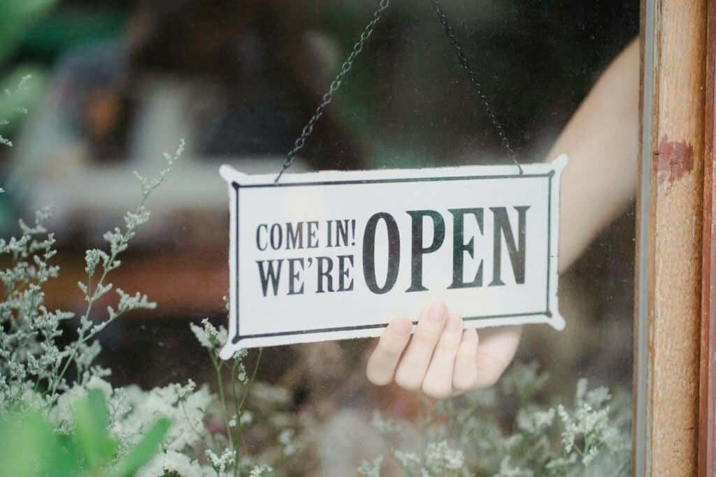 An image of a 'we're open' sign on a local Essex antique dealer shop.