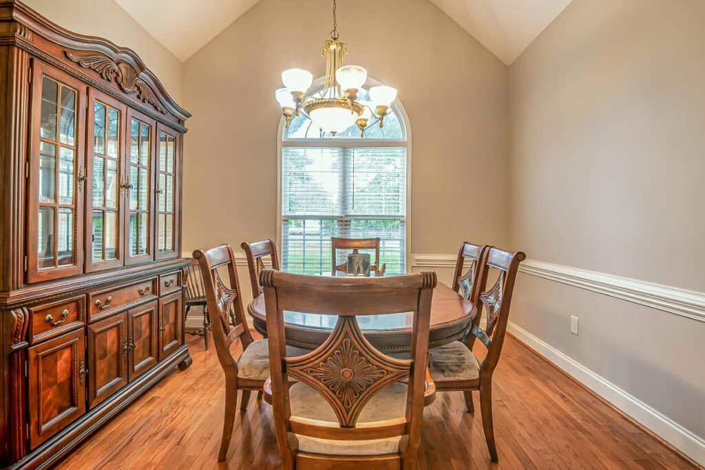 An image of vintage chairs around an antique table in a modern home.