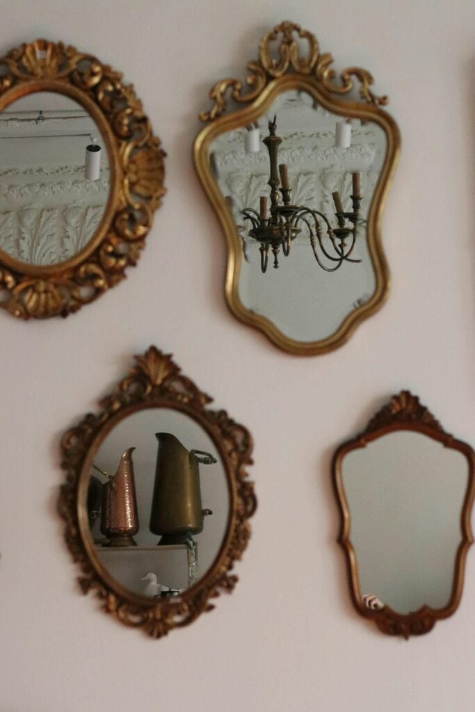 An image of antique and vintage mirrors hung on a lounge wall.